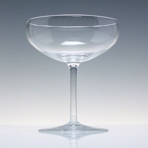 fig 2. A set of six clear Edwardian crystal champagne coupes with wide saucer bowls and slender stems arranged in a line.