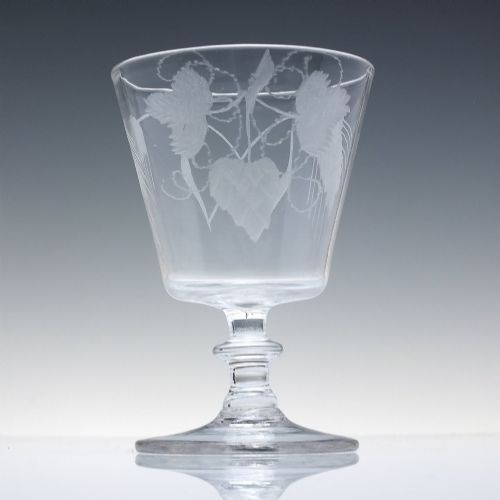 fig 1. A clear Georgian glass rummer with a cup-shaped bowl wheel-engraved with hop and barley motifs, set on a short knopped stem and flat circular base.