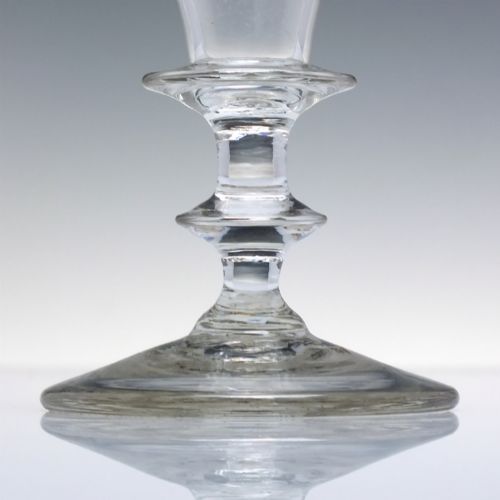 fig 3. A pair of clear hand-blown Georgian glass goblets featuring wheel-engraved motifs of hops and barley on conical bowls above knopped stems and conical bases.
