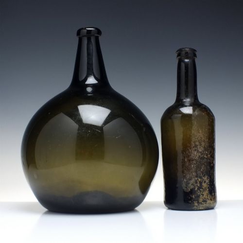 fig 1. A large, dark green hand-blown antique glass wine bottle with a bulbous body and tapered neck.