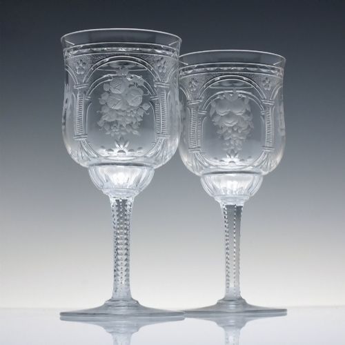 fig 1. A set of six clear lead crystal wine glasses featuring intricate acid-etched floral panels and textured facet-cut stems.