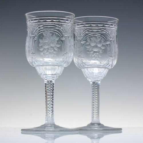 fig 1. A set of six clear lead crystal dram glasses featuring acid-etched floral panels set within archways and faceted diamond-cut stems.