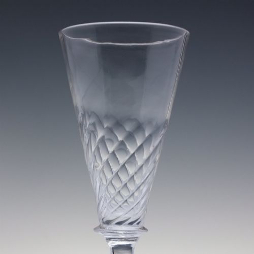 fig 1. A clear Georgian ale glass featuring half-wrythen spiral moulding on the conical bowl above a knopped stem.