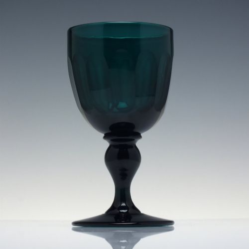 fig 1. An early 19th-century turquoise green glass wine goblet featuring a cut bowl and a knopped stem on a flat circular base.