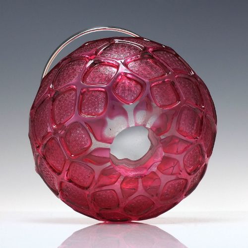 fig 4. A Victorian cranberry glass biscuit barrel featuring a diamond-quilted pattern with internal floral etching and a silver-plated rim, lid, and overhead swing handle.