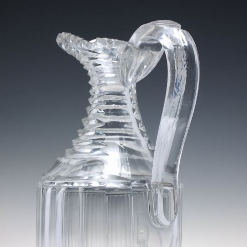 fig 2. A clear Georgian Regency cut glass claret jug with a step-cut neck, panelled body, applied handle, and faceted stopper.