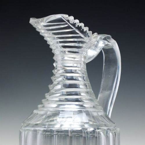 fig 3. A clear Georgian Regency cut glass claret jug with a step-cut neck, panelled body, applied handle, and faceted stopper.