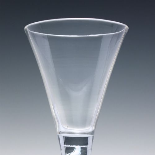 fig 3. An 18th-century clear lead glass wine glass featuring a flared trumpet bowl, a central white opaque twist stem, and a circular conical foot.