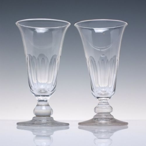 fig 1. A pair of clear cut-glass Georgian jelly glasses featuring flared rims, panel-cut lower bowls, short knopped stems, and circular flat bases.
