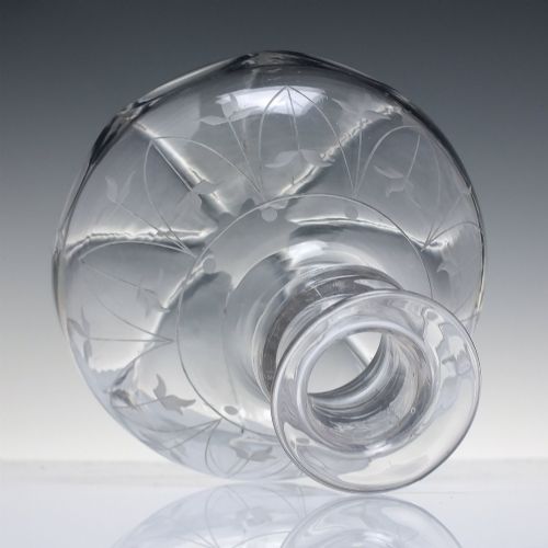 fig 1. A mid-19th century clear glass wine carafe featuring an engraved foliate upper band and cut panel arches around the bulbous base.