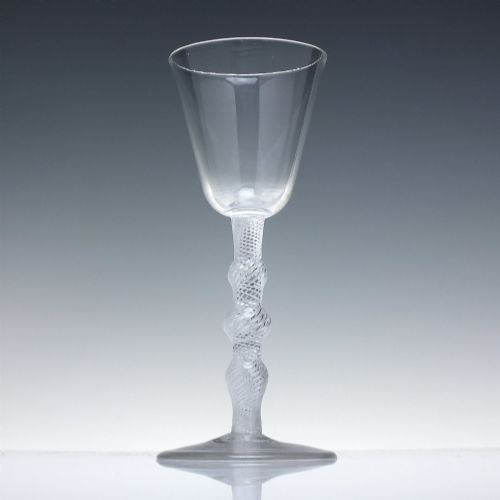 fig 1. An 18th-century clear lead glass wine glass featuring a knopped air twist stem and a bell-shaped bowl supported by a conical foot.