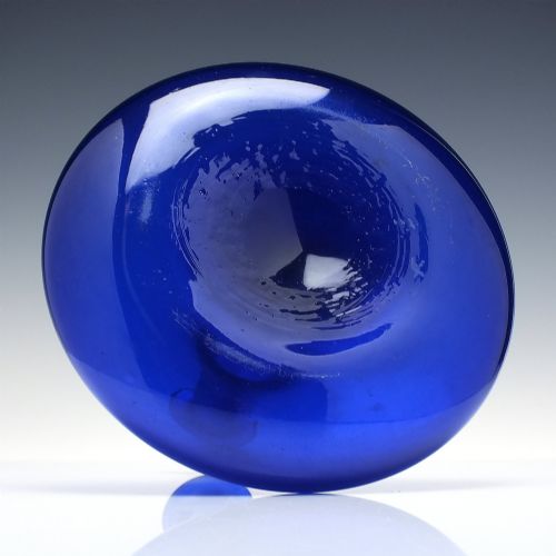 fig 4. A Georgian cobalt blue glass mell decanter with a wide rounded base, narrow neck, and a cork stopper with a metal ring labeled RUM.