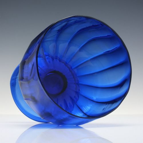 fig 2. A deep cobalt blue glass sugar bowl featuring a vertically ribbed body set upon a conical pedestal foot.