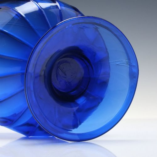 fig 4. A deep cobalt blue glass sugar bowl featuring a vertically ribbed body set upon a conical pedestal foot.