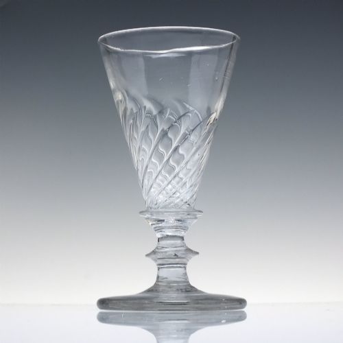 fig 1. A clear Georgian lead glass ale goblet featuring half wrythen spiral moulding on the conical bowl and a knopped stem.