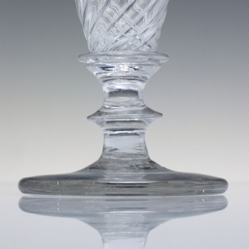 fig 2. A clear Georgian lead glass ale goblet featuring half wrythen spiral moulding on the conical bowl and a knopped stem.