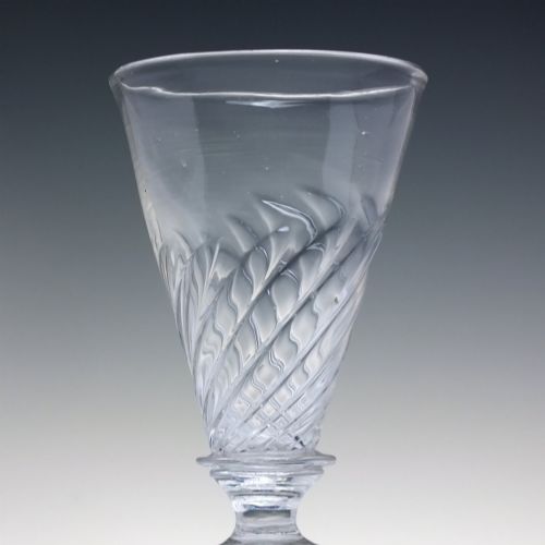 fig 3. A clear Georgian lead glass ale goblet featuring half wrythen spiral moulding on the conical bowl and a knopped stem.