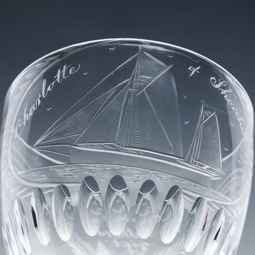 fig 4. A pair of clear glass Victorian wine goblets featuring wheel-engraved sailing ships, inscriptions, and cut oval fluting around the lower bowls.
