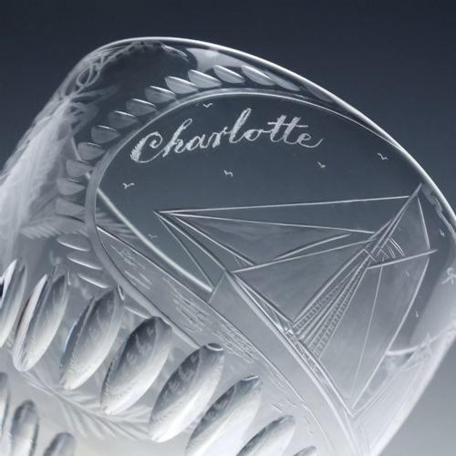 fig 5. A pair of clear glass Victorian wine goblets featuring wheel-engraved sailing ships, inscriptions, and cut oval fluting around the lower bowls.