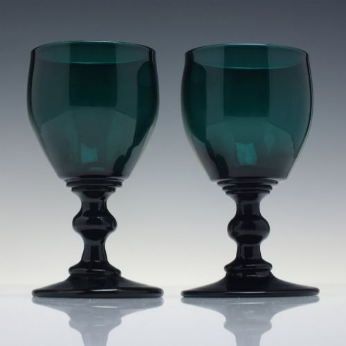 fig 1. A pair of deep emerald green Georgian hand-blown wine glasses featuring curved bucket bowls, knopped stems, and circular flat bases.
