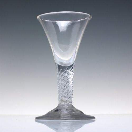 fig 1. A clear Georgian dram glass featuring a flared trumpet bowl, a multi-spiral air twist stem, and a broad conical foot.