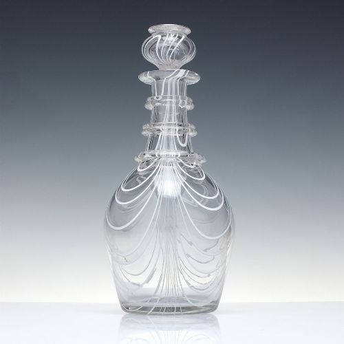 fig 1. A clear lead glass Regency Prussian-shaped personal spirit decanter decorated with combed opaque white trailing and fitted with a matching glass stopper.