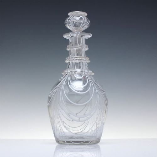 fig 2. A clear lead glass Regency Prussian-shaped personal spirit decanter decorated with combed opaque white trailing and fitted with a matching glass stopper.