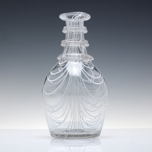 fig 3. A clear lead glass Regency Prussian-shaped personal spirit decanter decorated with combed opaque white trailing and fitted with a matching glass stopper.