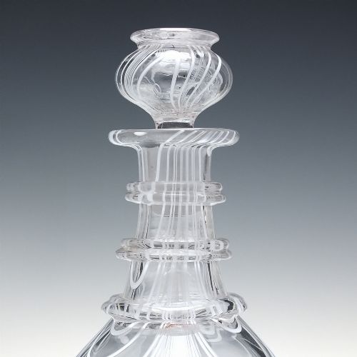 fig 4. A clear lead glass Regency Prussian-shaped personal spirit decanter decorated with combed opaque white trailing and fitted with a matching glass stopper.