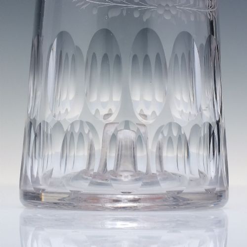 fig 4. An 18th-century clear glass sugar loaf bitters bottle featuring a faceted slender neck, cut panel base, and wheel-engraved lettering spelling BITTERS surrounded by floral swags.