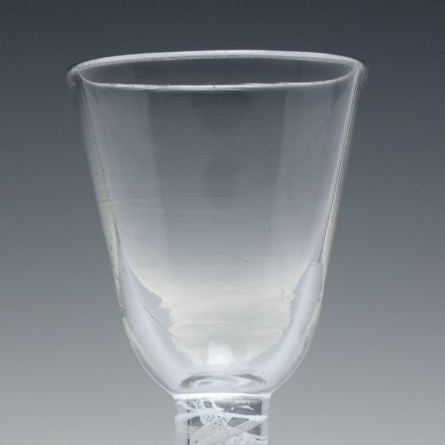 fig 3. An 18th-century clear glass wine glass featuring an internal white opaque twist stem and a thickened firing foot base.