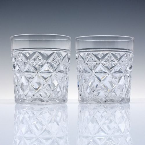 fig 1. A pair of clear cut-crystal whisky tumblers featuring a deep diamond geometric pattern and smooth polished rims.