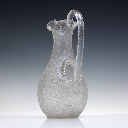 fig 1. A late 19th-century Victorian clear overshot glass champagne jug with a textured ice-glass surface, flared spout, and an applied ribbed clear handle.