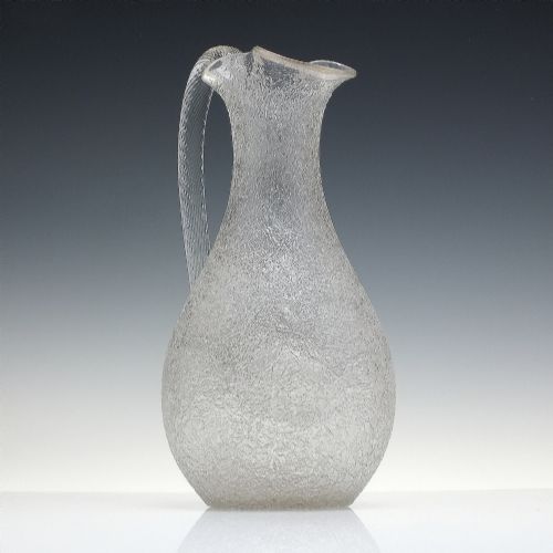 fig 2. A late 19th-century Victorian clear overshot glass champagne jug with a textured ice-glass surface, flared spout, and an applied ribbed clear handle.