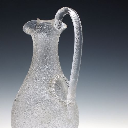 fig 4. A late 19th-century Victorian clear overshot glass champagne jug with a textured ice-glass surface, flared spout, and an applied ribbed clear handle.