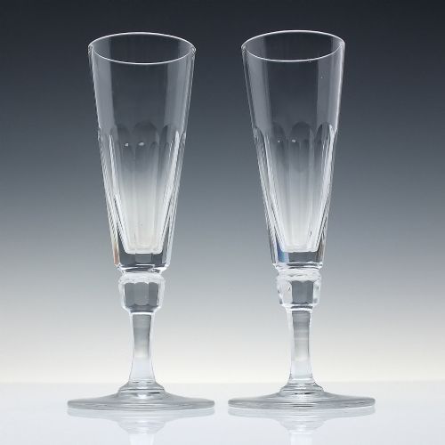 fig 1. A set of six Victorian clear cut glass champagne flutes arranged in a row, featuring tall conical bowls with basal panel cutting and faceted stems.