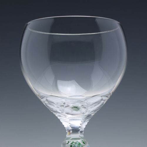 fig 2. A pair of clear glass wine goblets featuring round bowls and tall stems decorated with internal green and white opaque twists.