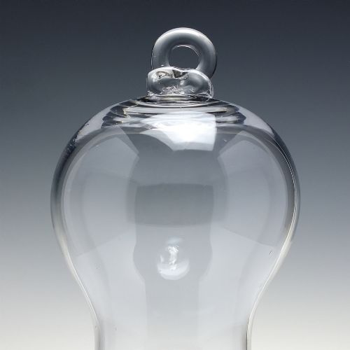 fig 2. A clear hand-blown glass bell cloche dome featuring a looped glass top handle and a flared base rim.