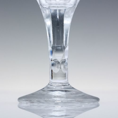 fig 2. An antique clear cut lead crystal dram glass featuring diamond lattice cutting on the bowl, a faceted stem, and a flat circular base.