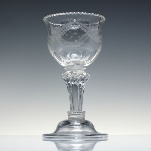 fig 1. An 18th-century Georgian clear glass sweetmeat vessel featuring a wheel-engraved rim, faceted pedestal stem, and domed circular foot.