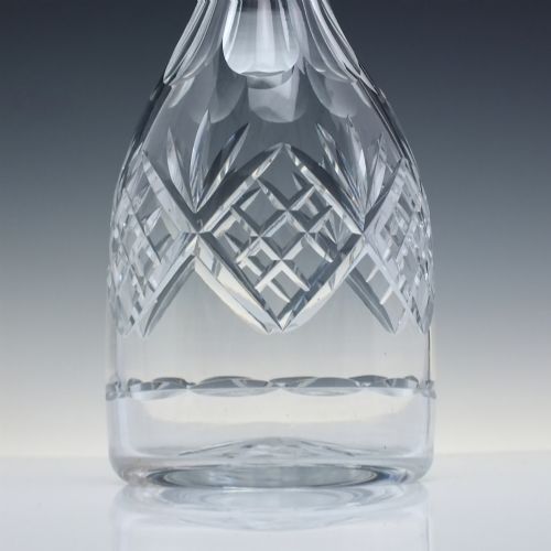 fig 2. A clear cut crystal glass decanter with a geometric diamond cut body, smooth neck, and faceted glass stopper.