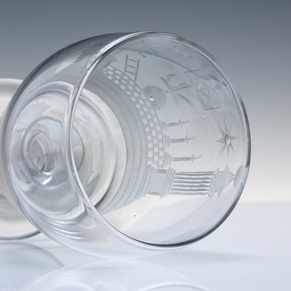 A clear 19th-century glass rummer featuring detailed wheel-engraved Masonic symbols, a knopped stem, and a flat circular base. View V