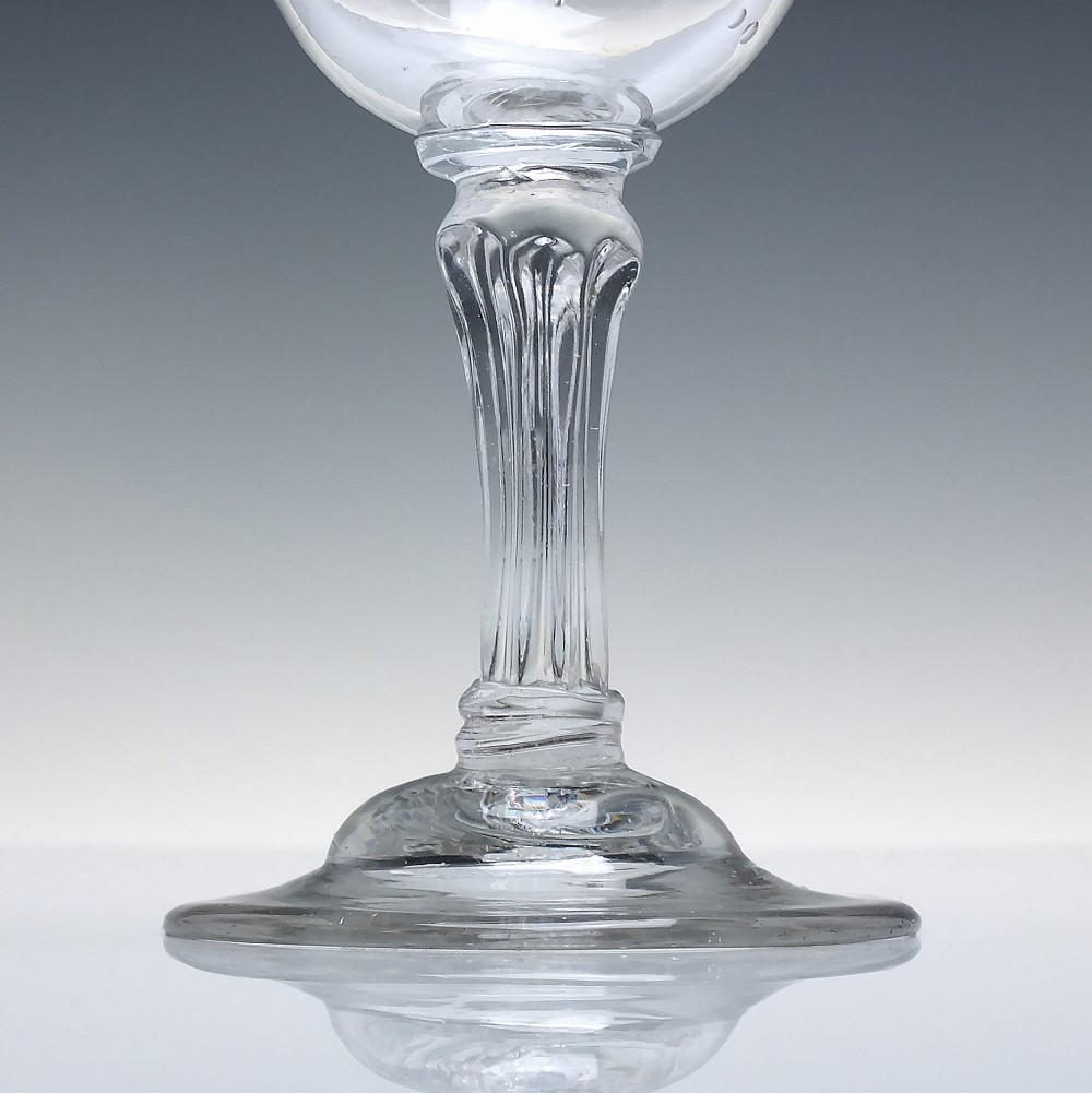 An 18th-century clear glass goblet featuring a bucket bowl supported by a ribbed pedestal stem and a flared round foot. View III