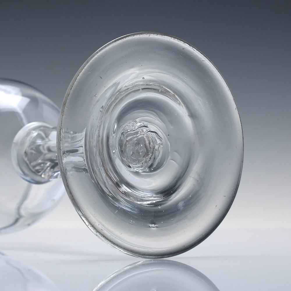 An 18th-century clear glass goblet featuring a bucket bowl supported by a ribbed pedestal stem and a flared round foot. View VI