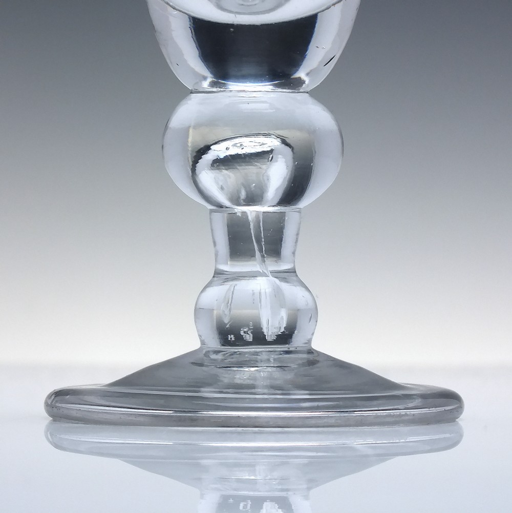 An early 18th-century clear lead glass dram vessel featuring a trumpet-shaped bowl and a heavy baluster knopped stem on a circular foot. View III