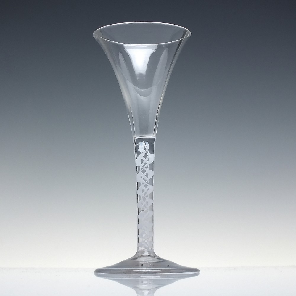 A Georgian wine glass featuring a clear trumpet-shaped bowl resting on a straight stem with an internal white opaque double series twist spiral and a conical foot. View II