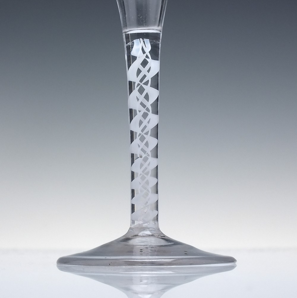 A Georgian wine glass featuring a clear trumpet-shaped bowl resting on a straight stem with an internal white opaque double series twist spiral and a conical foot. View III