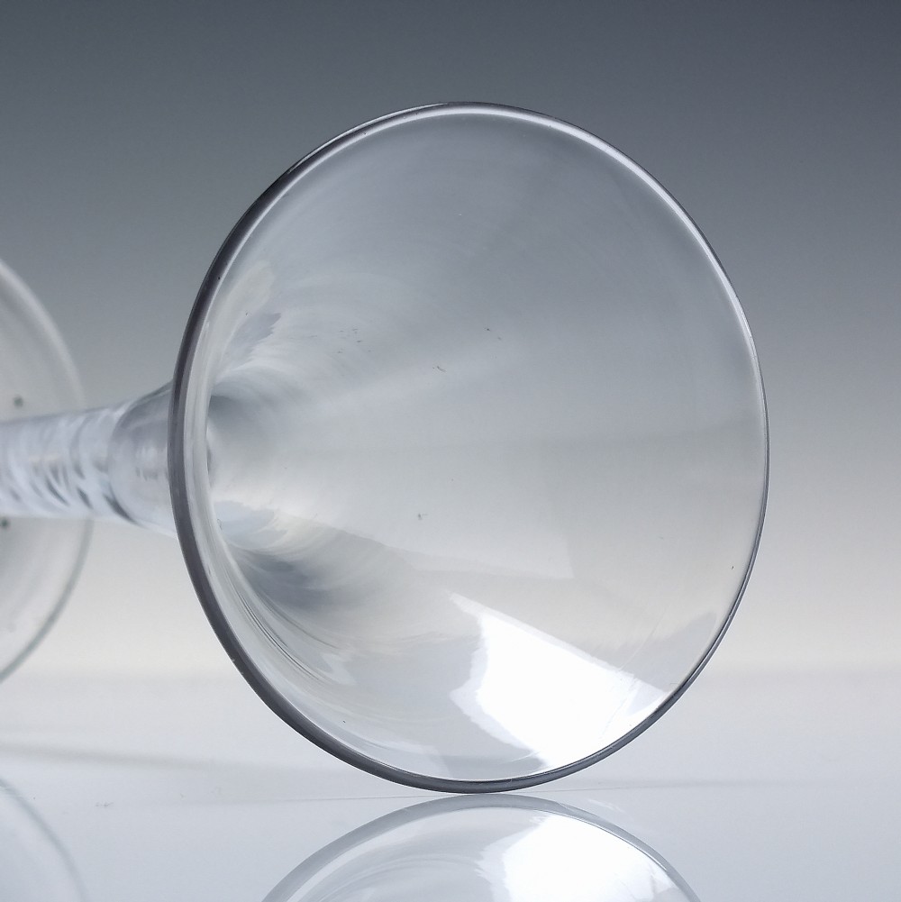 A Georgian wine glass featuring a clear trumpet-shaped bowl resting on a straight stem with an internal white opaque double series twist spiral and a conical foot. View V