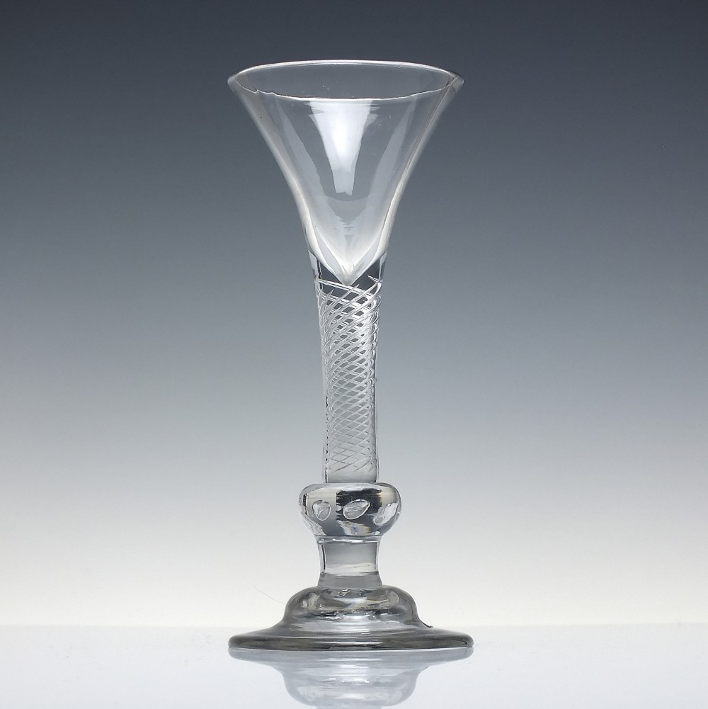 An 18th-century Georgian clear lead glass wine glass featuring a flared bell bowl, an air twist stem with a central knop, and a wide domed foot. View II