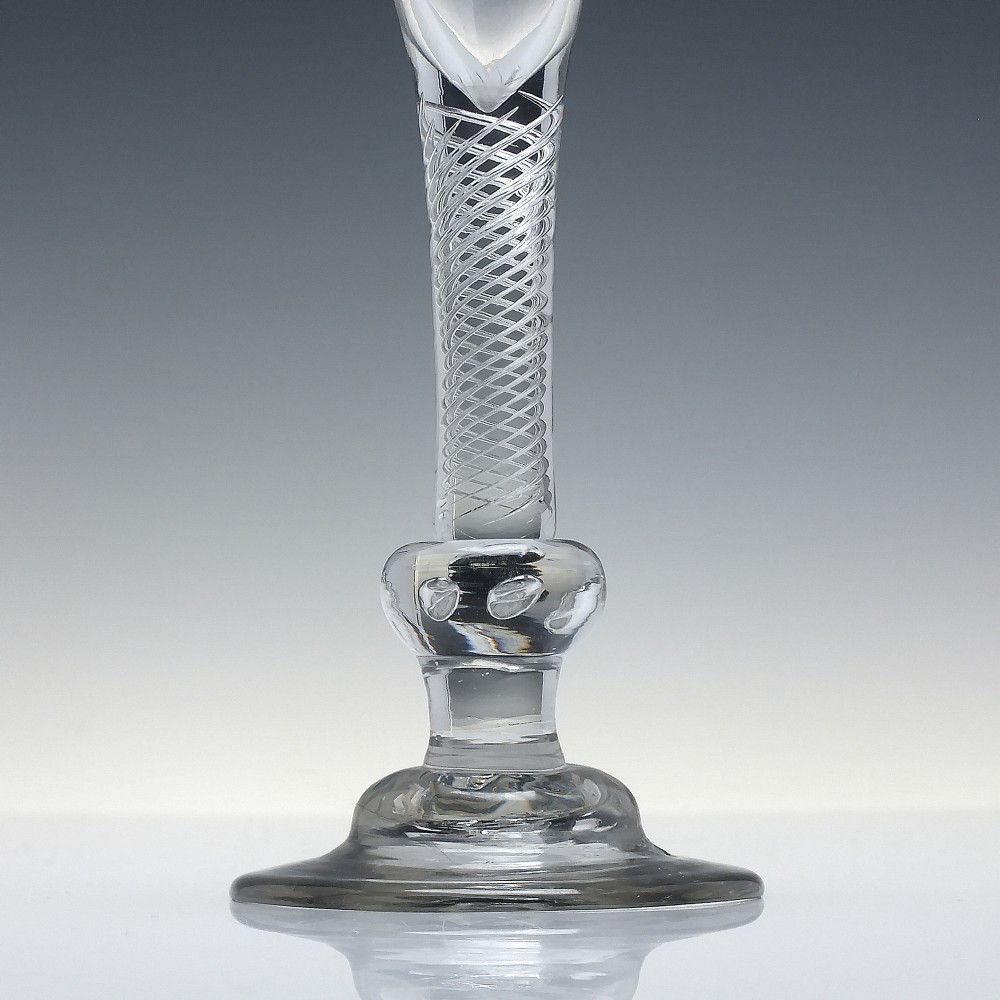 An 18th-century Georgian clear lead glass wine glass featuring a flared bell bowl, an air twist stem with a central knop, and a wide domed foot. View III